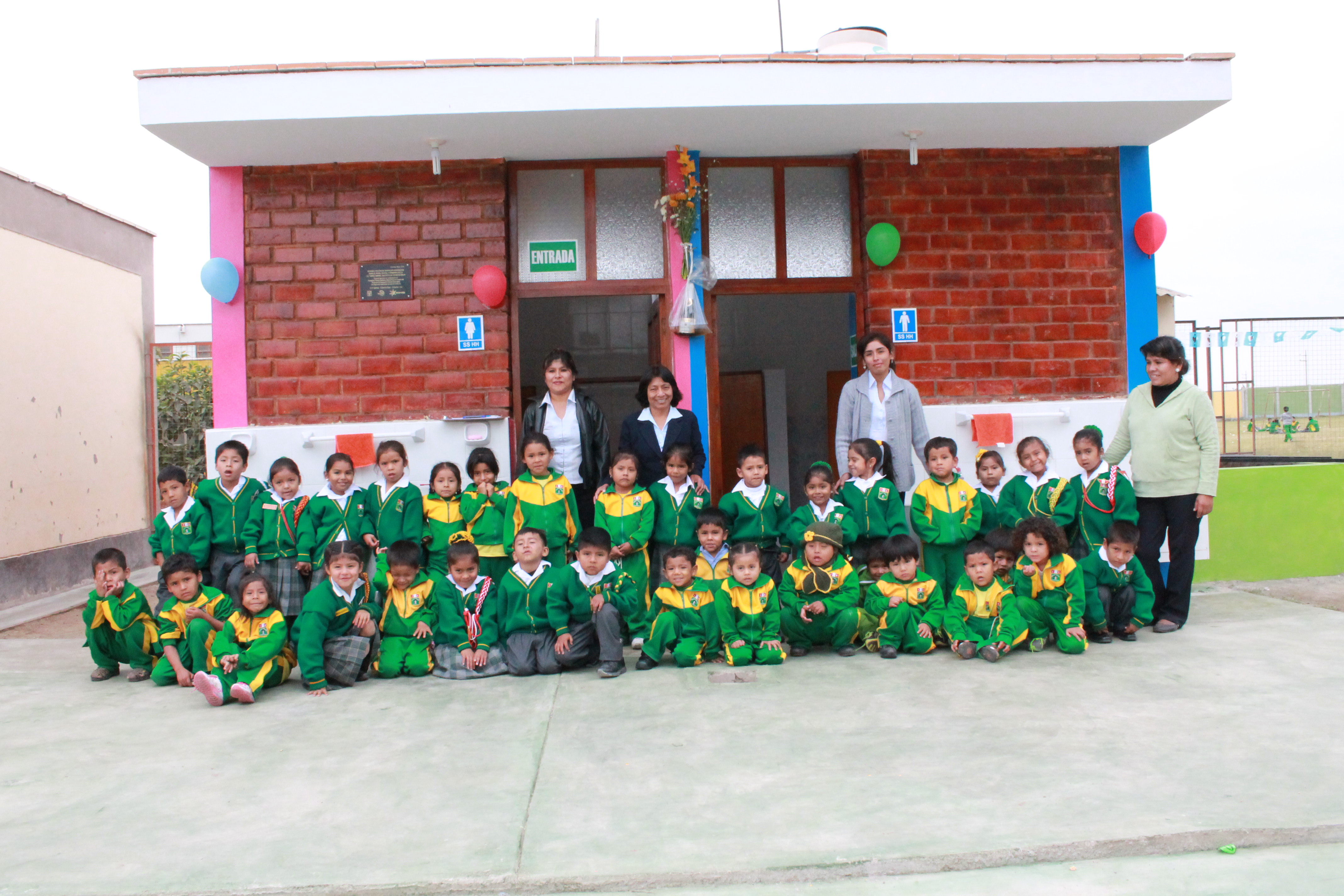 Niños y niñas de la IE Túpac Amaru, Chincha Baja juntos a los servicios higiénicos instalados.